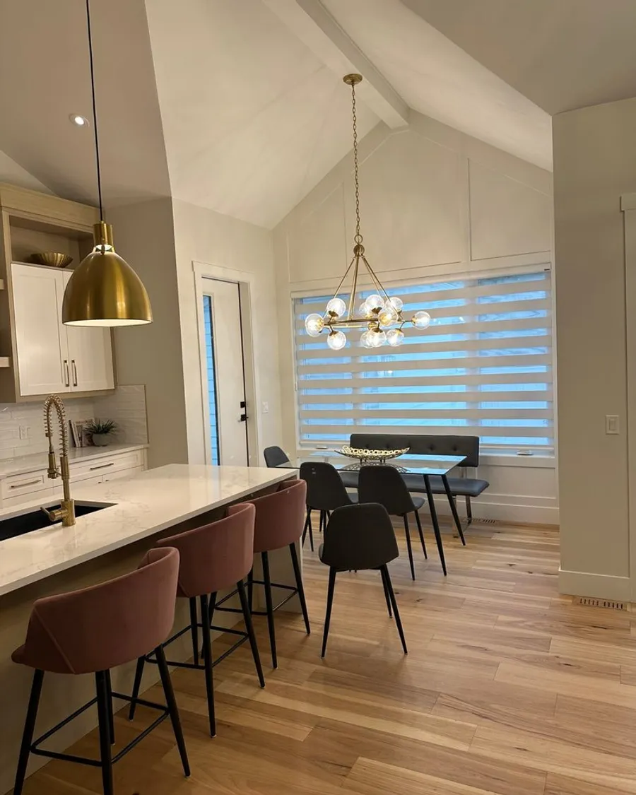 Motorized smart blinds lowering over tall kitchen windows in a Calgary home