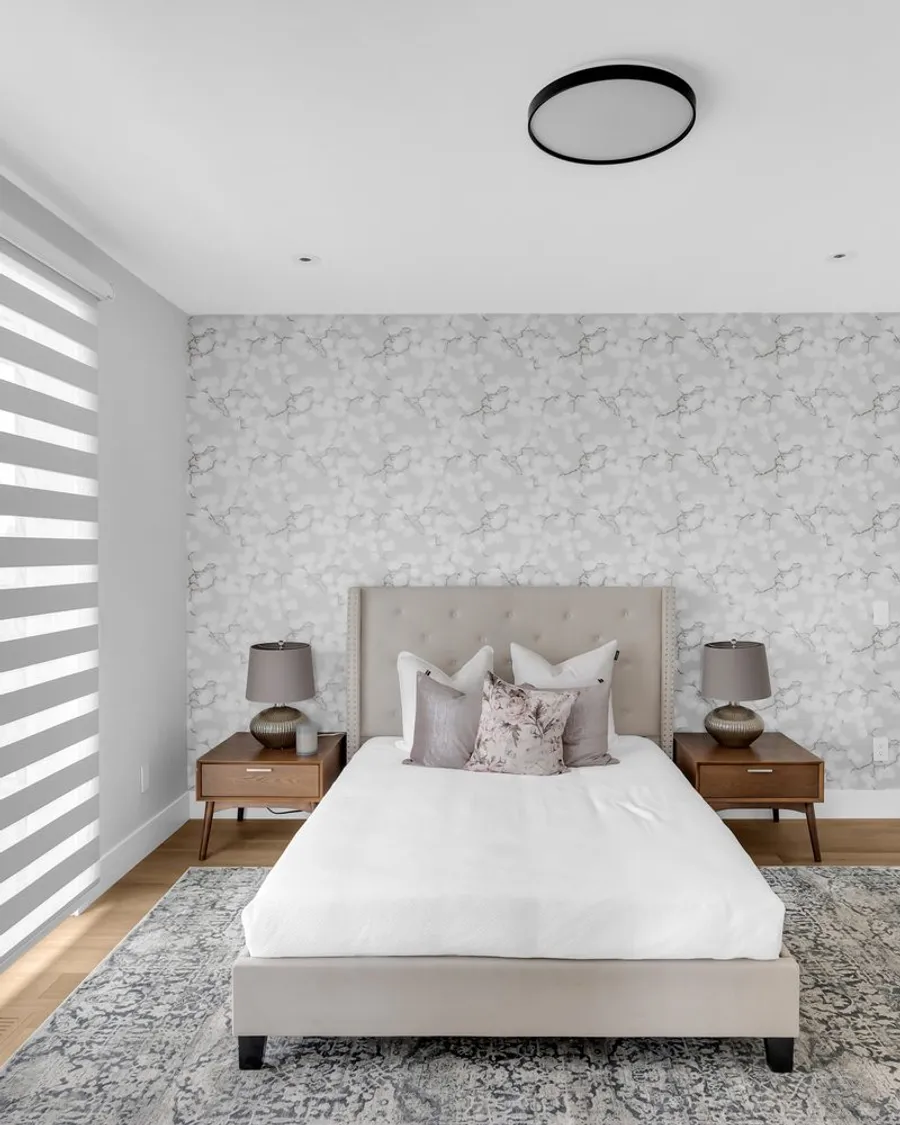Bedroom with a textured feature wall covering behind the bed in a Calgary home